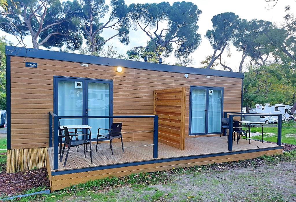 een kleine hut met een tafel en stoelen op een terras bij Camping Osuna in Madrid