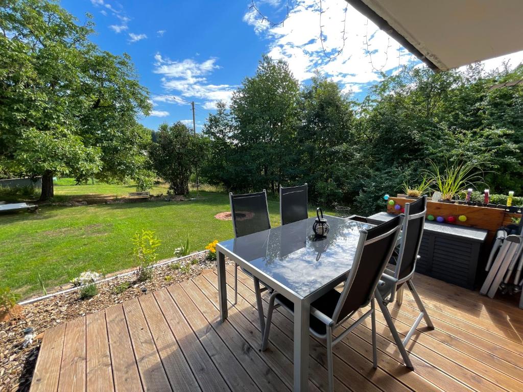 a patio with a table and chairs on a deck at Schöne Ferienwohnung mitten im Pfälzerwaldgebiet in Leimen