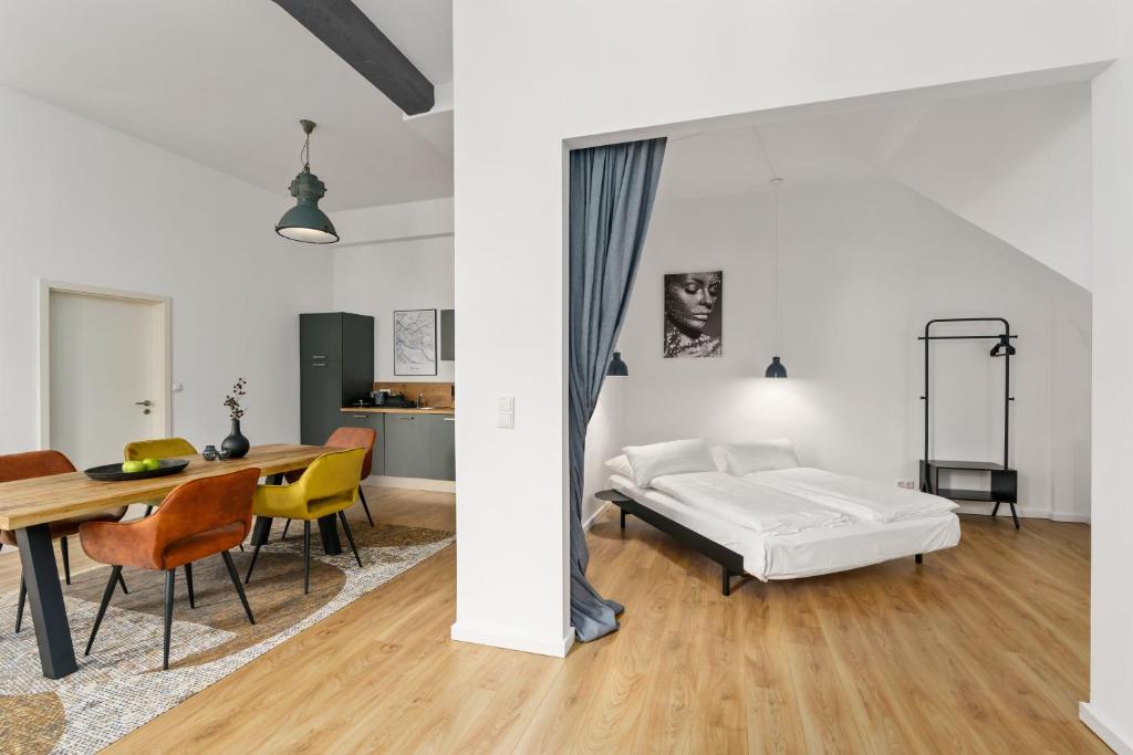 a bedroom with a bed and a table and chairs at MEL&BENS Loft-Appartements Terrasse Weserstadion in Bremen