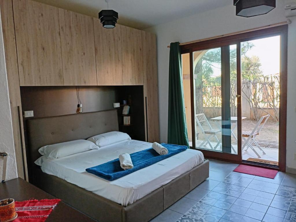 a bedroom with a large bed and a large window at Studio Apartment Residenza del Sole in La Maddalena