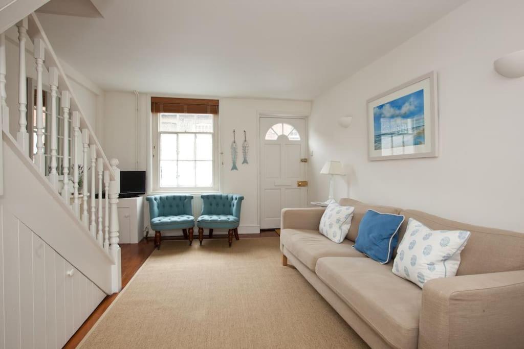 a living room with a couch and blue chairs at Quaker Cottage in historic Arundel in Arundel
