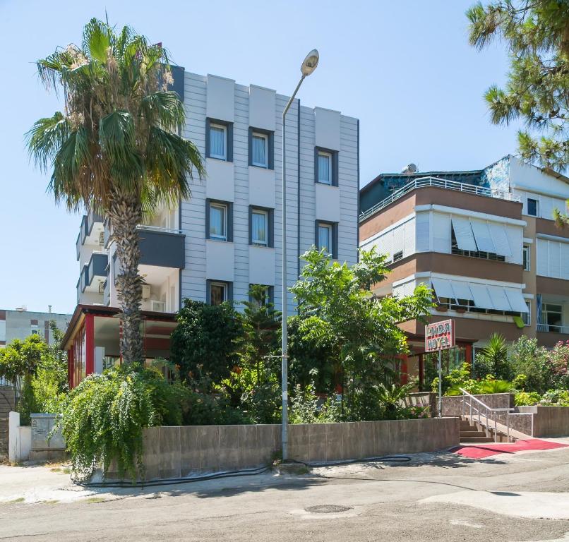 un edificio alto con una palmera delante de él en Enda Lara Hotel, en Antalya