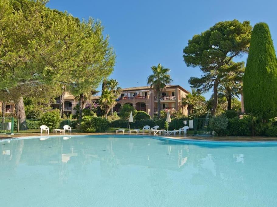 a large swimming pool with chairs and a building at Superbe Appartement à 50 m de la mer in Hyères