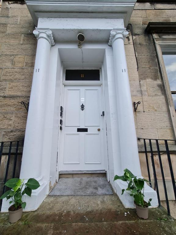 una puerta blanca en un edificio con dos columnas en Pilrig St Rooms, en Edimburgo