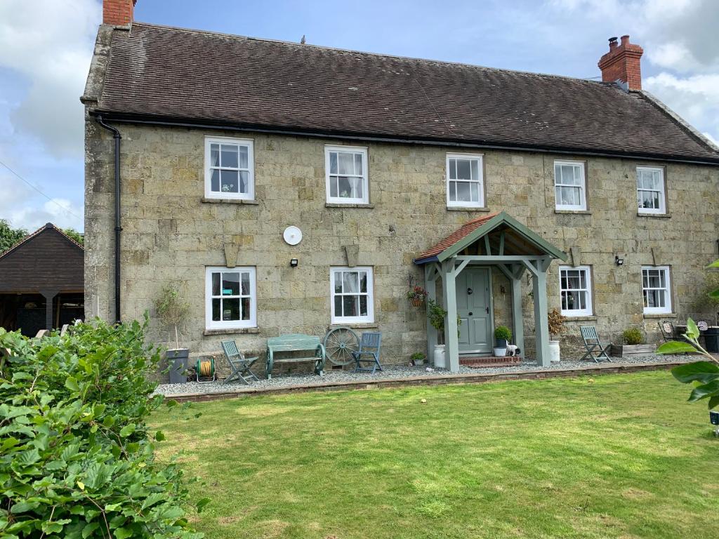 una gran casa de piedra con un patio verde en Lodbourne House B&B en Gillingham