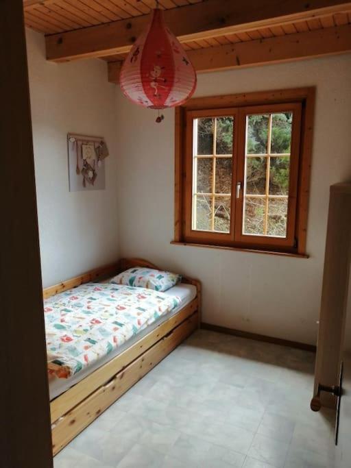 una camera con un letto in una stanza con una finestra di Confortable chalet avec magnifique vue en Gruyère. a Charmey