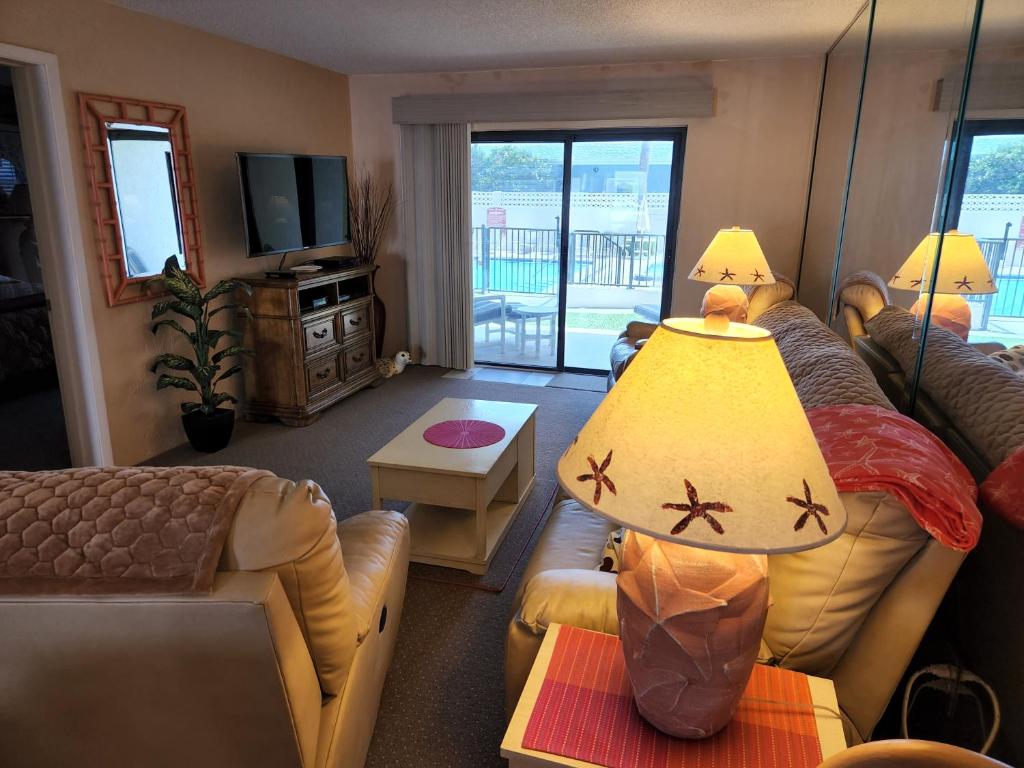 a living room with a couch and a table at 107 - 2/2 Poolside in Edgewater