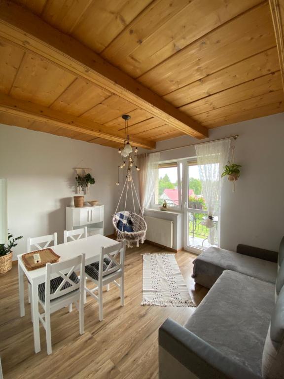 un soggiorno con tavolo bianco e divano di Agroturystyka Pod Modrzewiem a Zubrzyca Górna