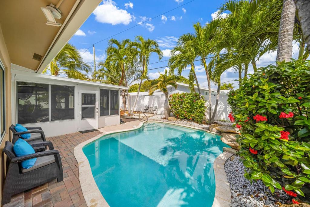 - une piscine dans l'arrière-cour d'une maison avec des palmiers dans l'établissement 3BDR Villa-HeatedPool-6minFt.Lauderdale Beach-8PPL, à Fort Lauderdale