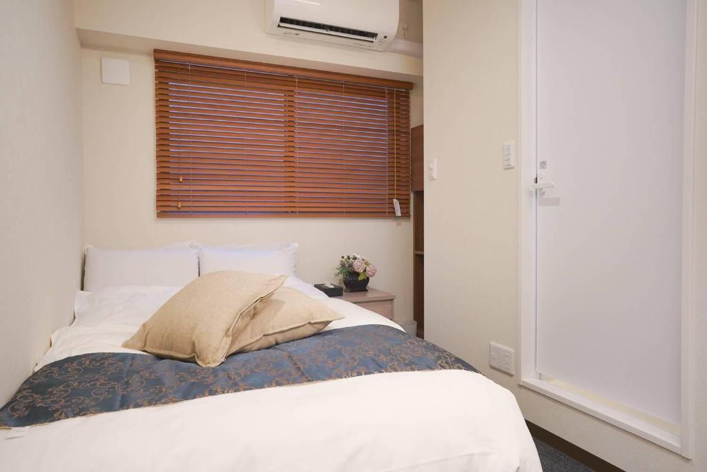1 dormitorio con cama con almohada y ventana en Hotel Plaisir Akihabara, en Tokio