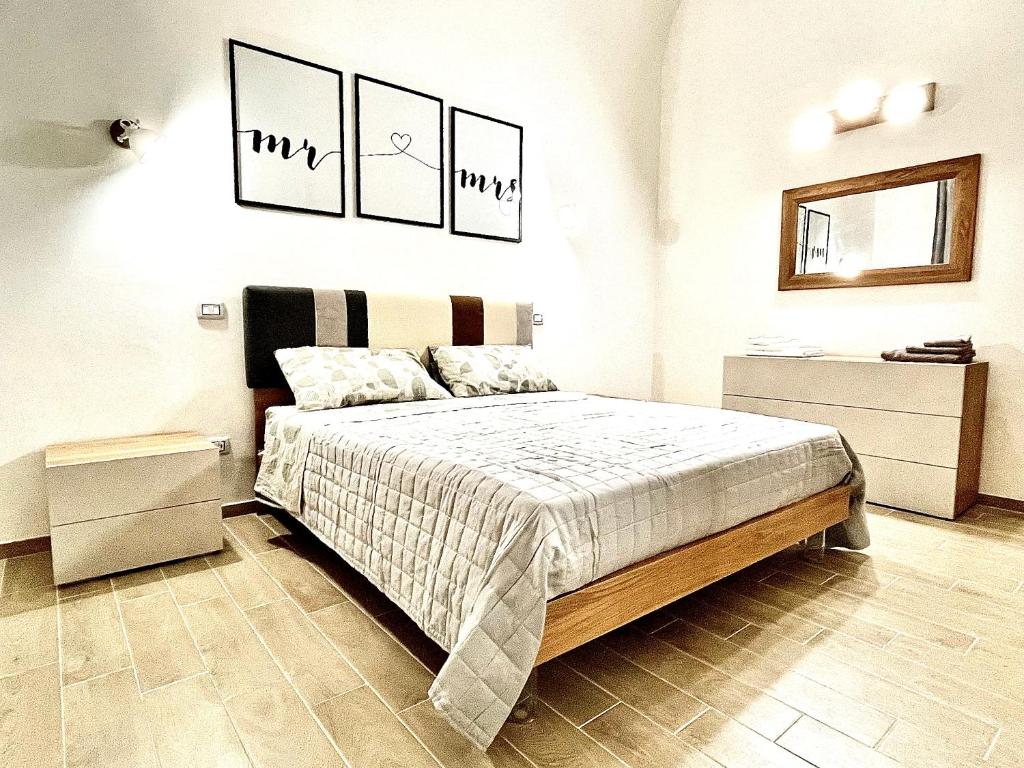 ein Schlafzimmer mit einem Bett und zwei Bildern an der Wand in der Unterkunft Casa Lello in Taranto