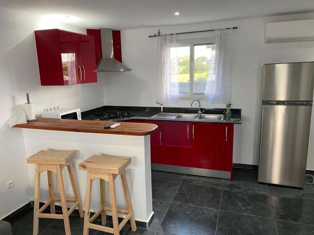 a kitchen with red cabinets and a stainless steel refrigerator at Domaine de Dugay in Beauregard