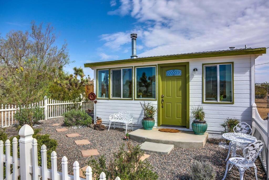 a small house with a green door and a fence at JT Cottage in Yucca Valley