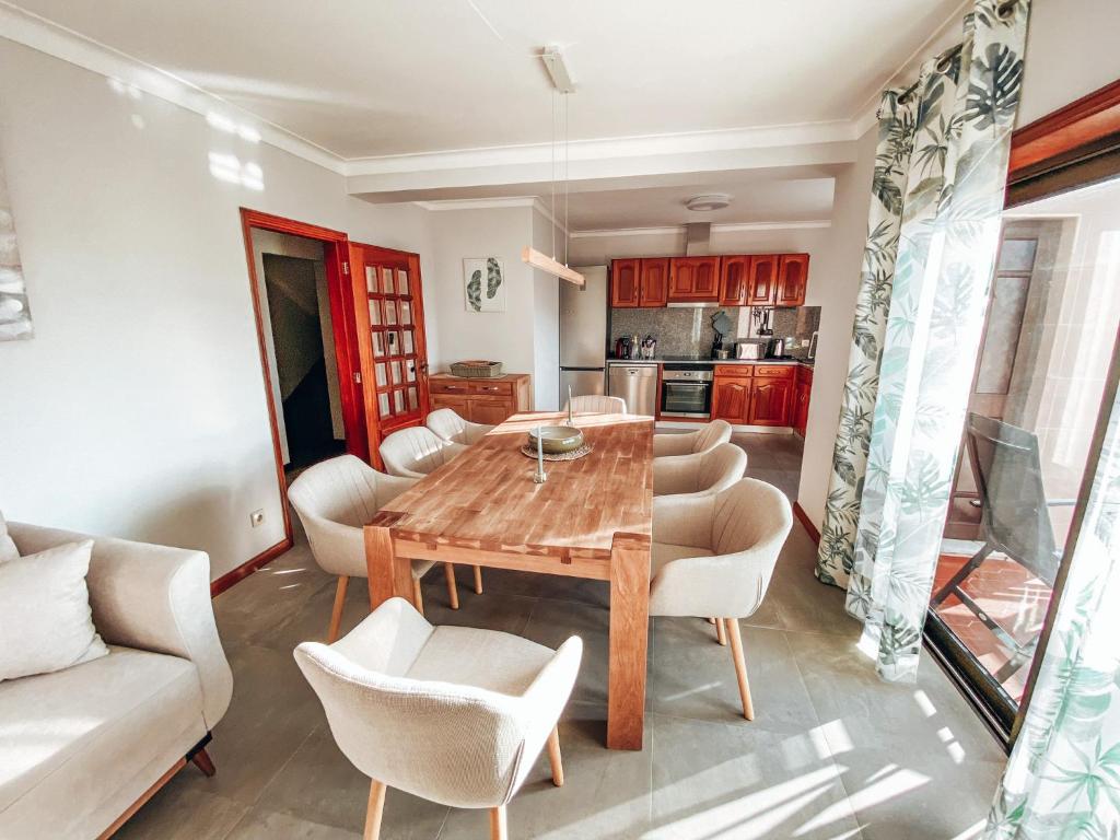 a kitchen and dining room with a wooden table and chairs at Casa Riamar in São Jacinto