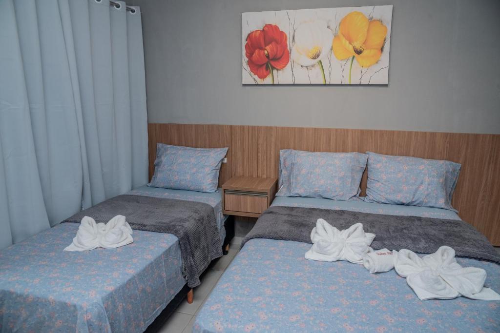 duas camas com toalhas num quarto em Suítes 590 em Penha
