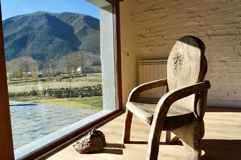 a wooden chair sitting in front of a window at El Parreiro VUT-LE-610 Dúplex in Villablino