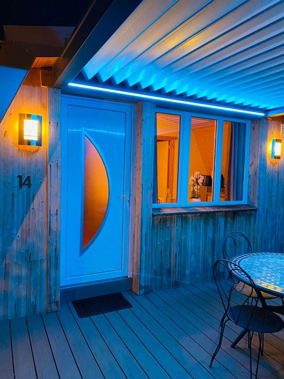 a patio with a table and a blue light at Au-Doux-Altic chalet romantique avec JACUZZI ET SAUNA in Métabief