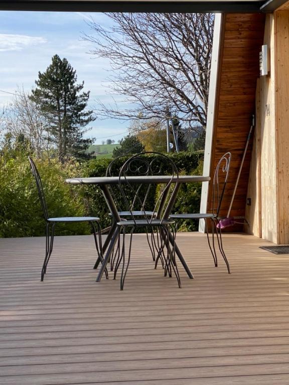 a table and two chairs sitting on a porch at Au-Doux-Altic chalet romantique avec JACUZZI ET SAUNA in Métabief