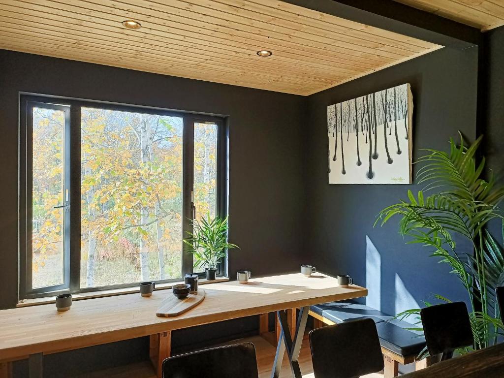 a dining room with a table and a window at Hooting Owl private ski chalet in Niseko