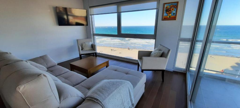 a living room with a couch and a view of the beach at Ventana al Golfo in Puerto Madryn