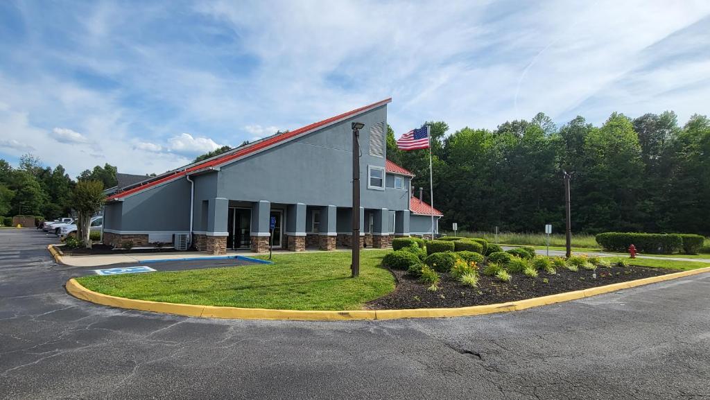 a building with an american flag in a parking lot at Stonewood Inn & Suites of Carrollton - Smithfield in Carrollton