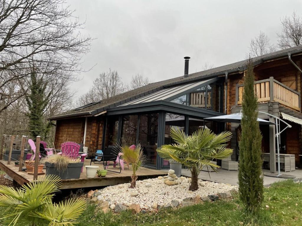 a log house with a porch and a patio at Gîte Saint-Rémy-en-Rollat, 5 pièces, 6 personnes - FR-1-489-370 in Saint-Rémy-en-Rollat