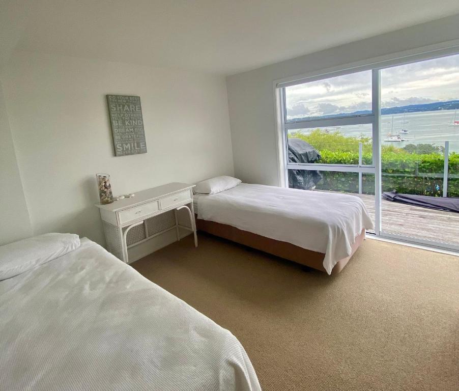 a bedroom with two beds and a large window at Wharf View in Russell