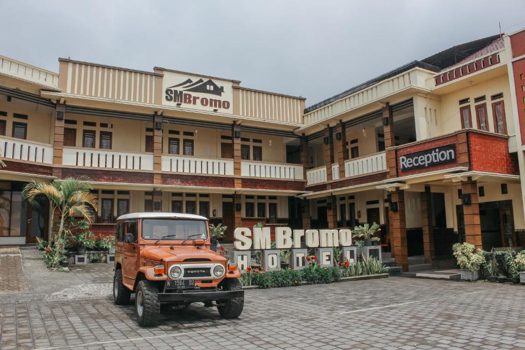 un jeep naranja estacionado frente a un edificio en SM Bromo Hotel, en Probolinggo