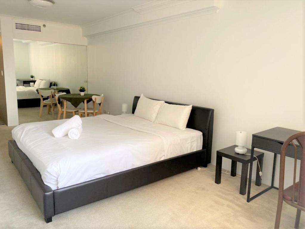 a bedroom with a large bed with white sheets and pillows at KozyGuru / Haymarket SYD / Cozy Warm / 1 Bed APT / NHA317-546B in Sydney