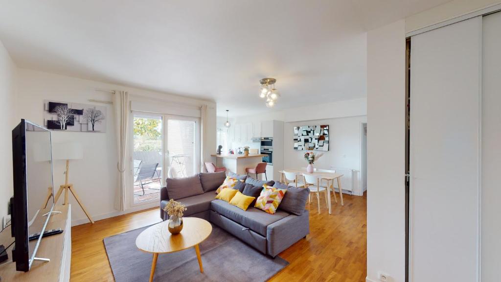 uma sala de estar com um sofá e uma mesa em Live Like a Local Stylish 2BR with Balcony & Parking em Saint-Denis