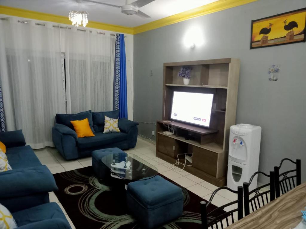 sala de estar con sofás azules y TV en Mtwapa HomeStay 3br Apartments en Mombasa