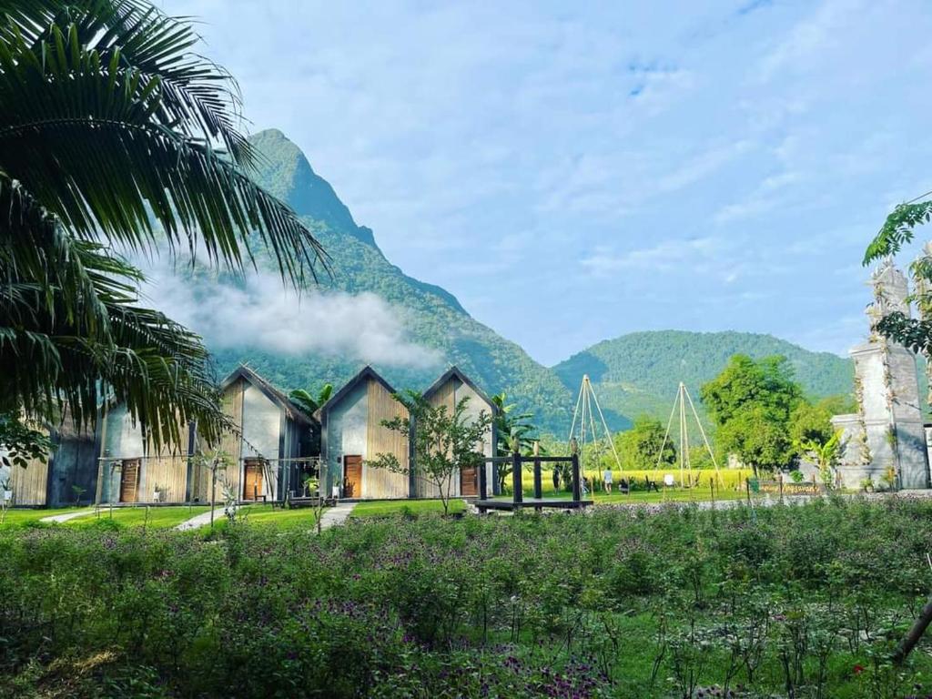 Une maison avec des montagnes en arrière-plan dans l'établissement Vangvieng Angsavanh Resort, à Vang Vieng