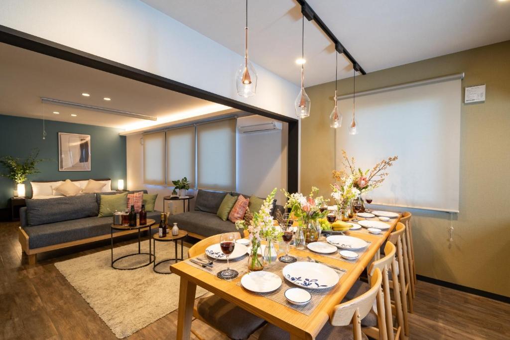 een eetkamer met een tafel en een bank bij HOUSE HOTEL MASHU - Vacation STAY 88249 in Sapporo