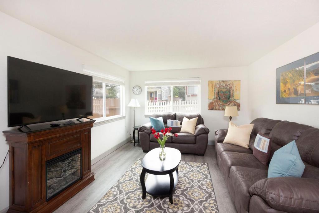 a living room with a couch and a television at RIVERWALK SEASIDE- Walk to beach, One level home, pet friendly in Seaside