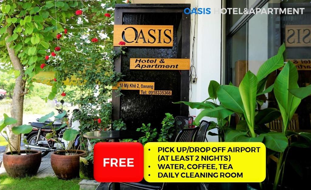 a sign in front of a building with plants at Oasis Hotel & Apartment in Da Nang