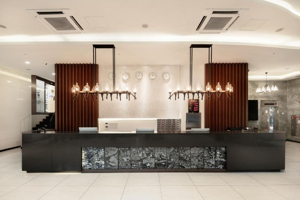 a lobby with a black counter with chandeliers at Hotel Bernoui Seoul in Seoul