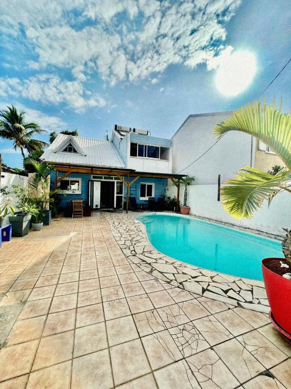 a house with a swimming pool in front of a house at Villa KaZabona Saint-Pierre - Chambres d'hôte in Saint-Pierre