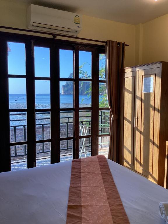 a bedroom with a bed and a view of the ocean at Phi Phi Green House & Sunsky Hostel in Phi Phi Islands