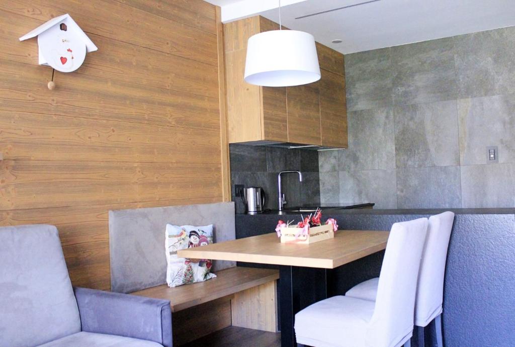 eine Küche mit einem Tisch und Stühlen im Zimmer in der Unterkunft ALPINE HOUSE - Dolomiti Affitti in Cavalese