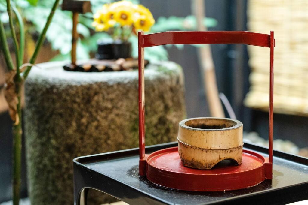 京都市にあるゲストハウス至の宿 Shibainu-Themed Guesthouseの赤い台付きテーブルの木製カップ