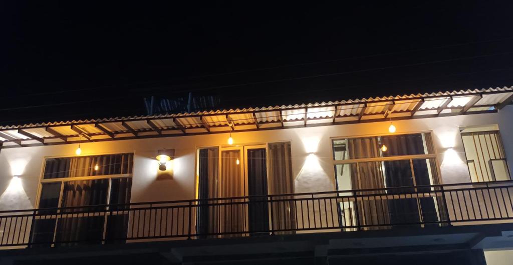 - un bâtiment blanc avec des fenêtres et un balcon la nuit dans l'établissement Lakshan home, à Ahangama