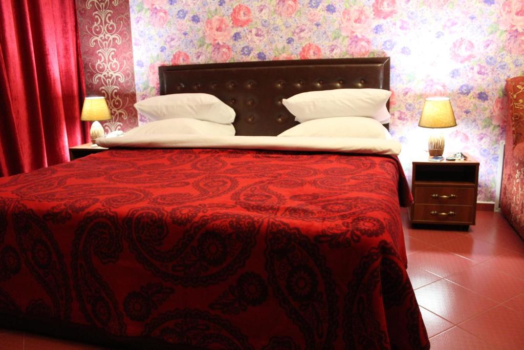 a bedroom with a large bed with a red bedspread at Voskhod Hotel in Kyiv