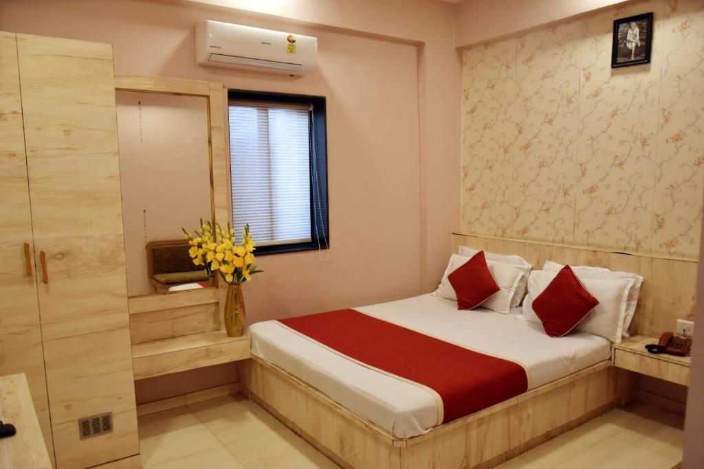 a hotel room with a bed and a window at Hotel Saideep Villas, Shirdi in Shirdi