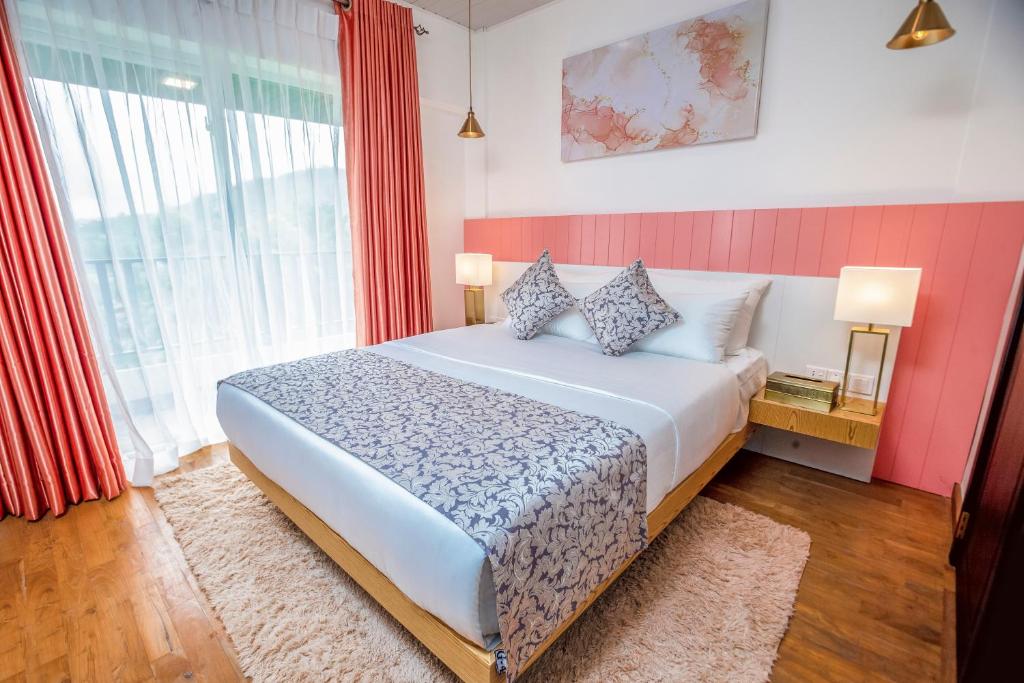 1 dormitorio con cama y ventana grande en The Breeze Luxury Apartment, en Nuwara Eliya
