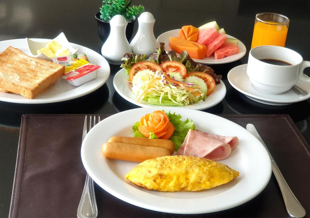 a table with plates of breakfast food on it at The Grand Sathorn in Bangkok