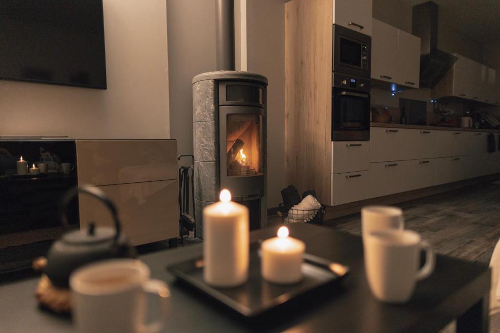 uma sala de estar com um fogão com velas numa mesa em L'Orgelétaine : Grande Maison au milieu des Lacs du Jura em Orgelet