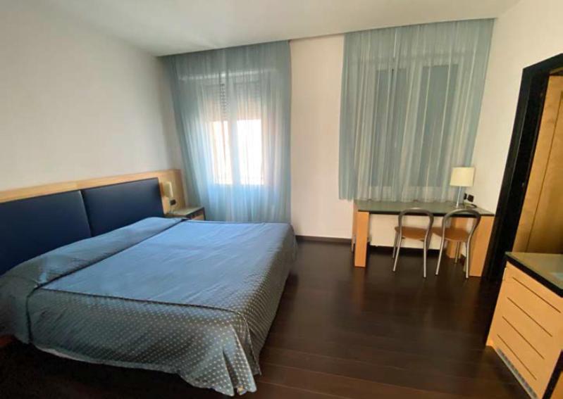 um quarto com uma cama, uma mesa e uma secretária em Luxury Rooms Padova Station em Pádua