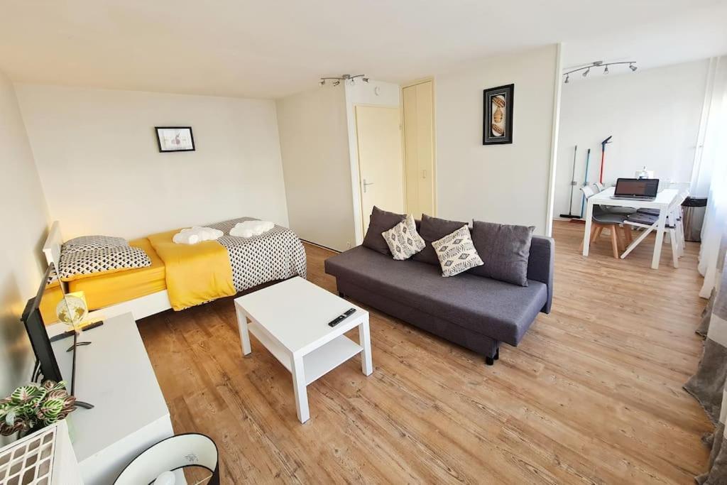 a living room with a couch and a table at L'Alex Solj-Studio spacieux en résidence avec parking privée - Easy check-in - Arrivée autonome in Évry-les-Châteaux
