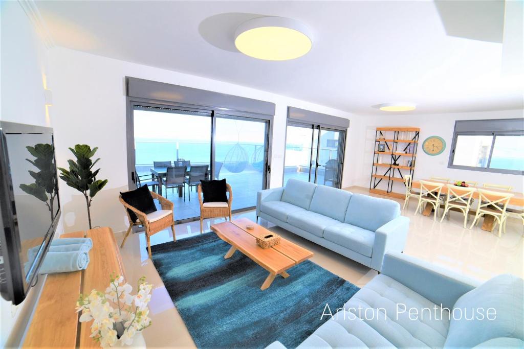 a living room with a blue couch and a table at Yalarent Tiberias Ariston Apartments & Penthouse in Tiberias