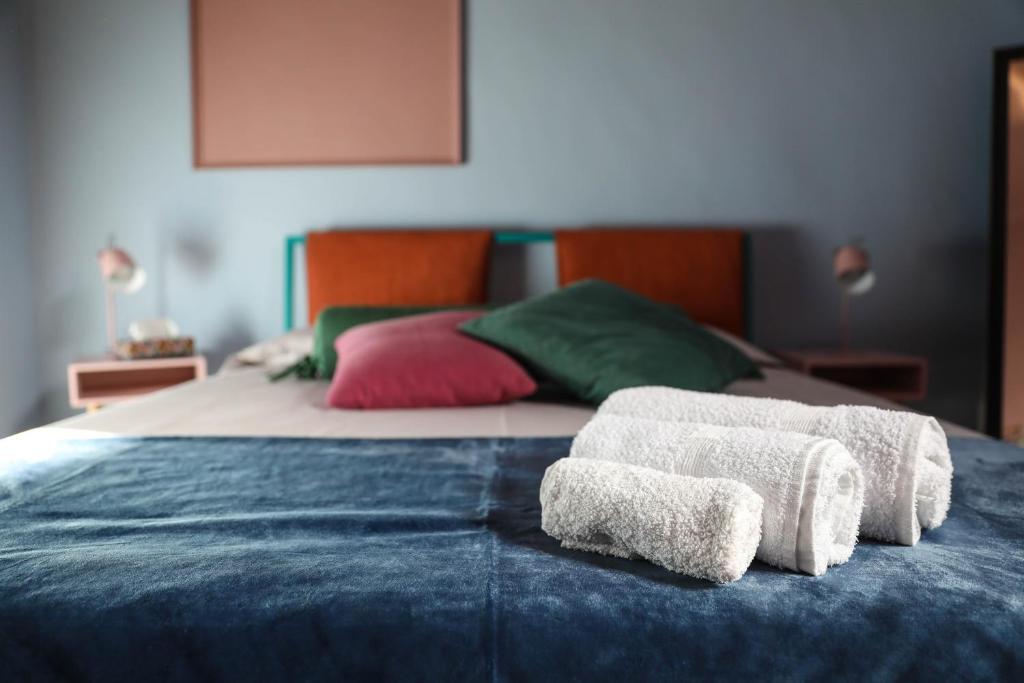 een bed met drie handdoeken en een bed bij The colors house in Bari